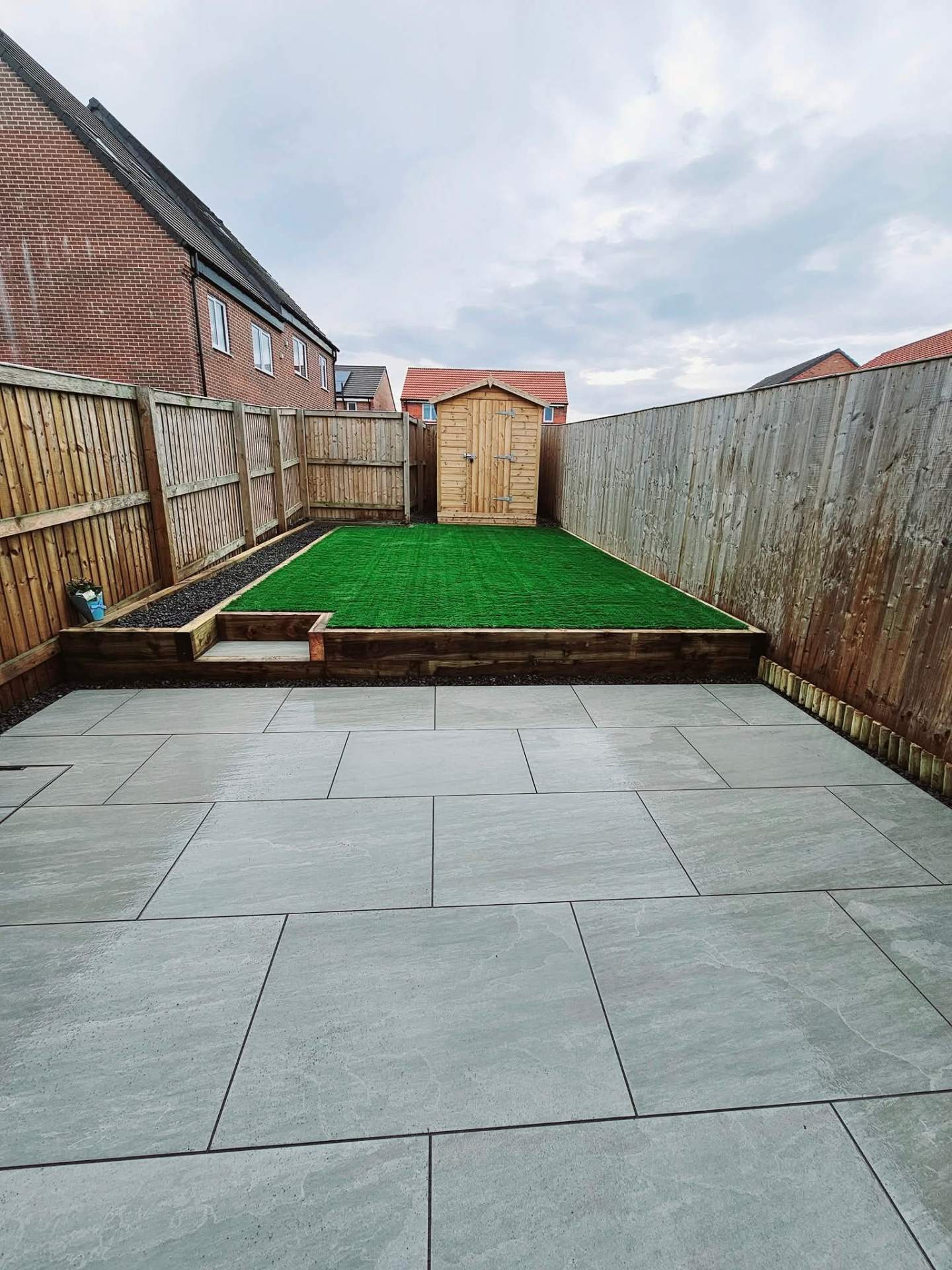 Porcelain patio with artificial lawn and new fencing by Star Renovations